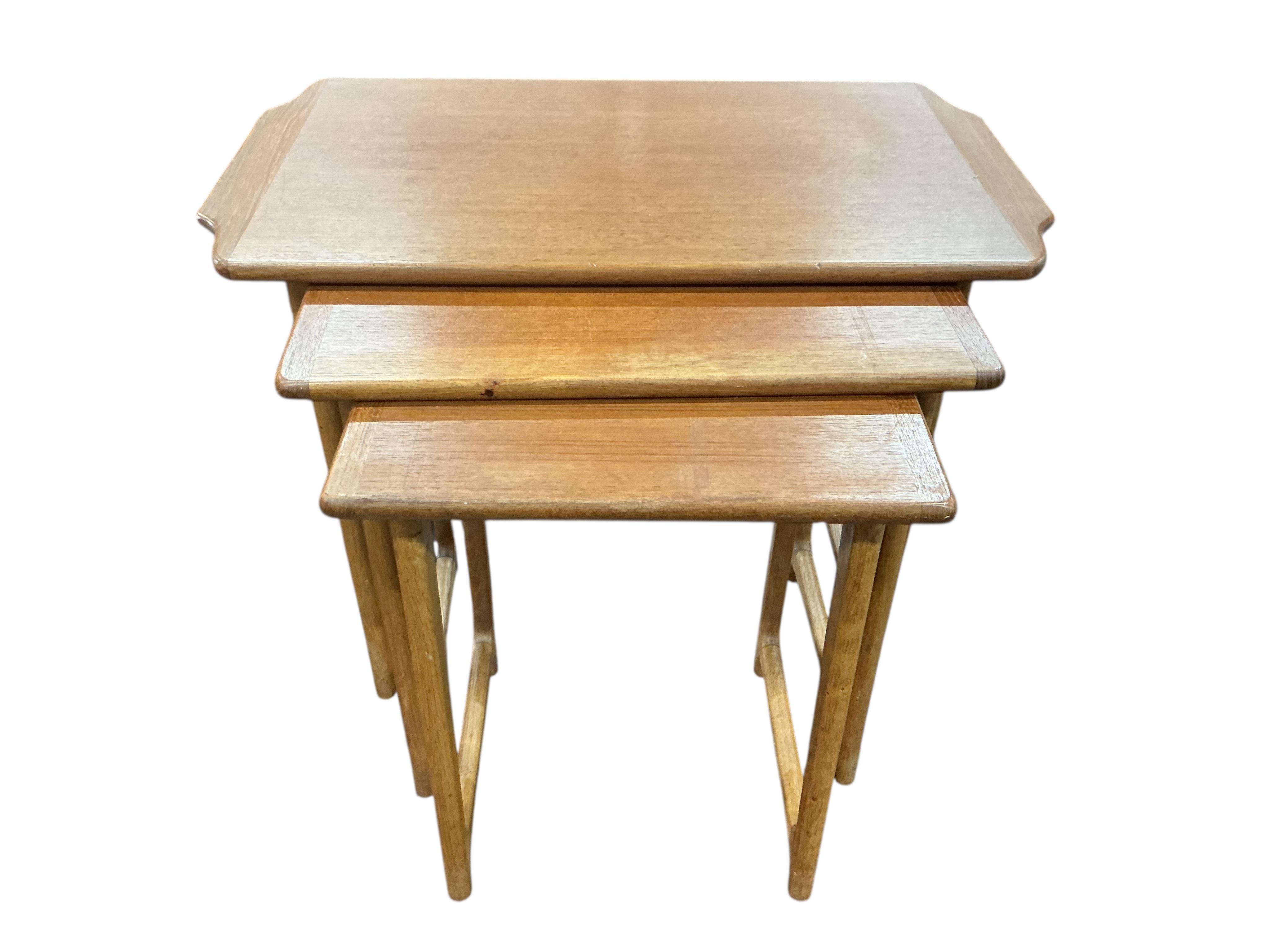 A nest of three mid century teak rectangular tables, width 65cm, depth 38cm, height 51cm